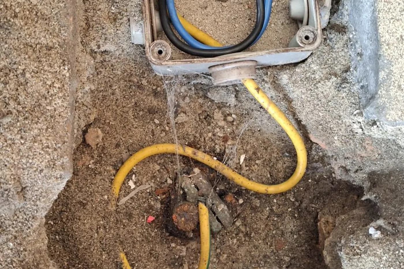 Arqueta abierta con la pica oxidada y el conductor de tierra amarillo y verde